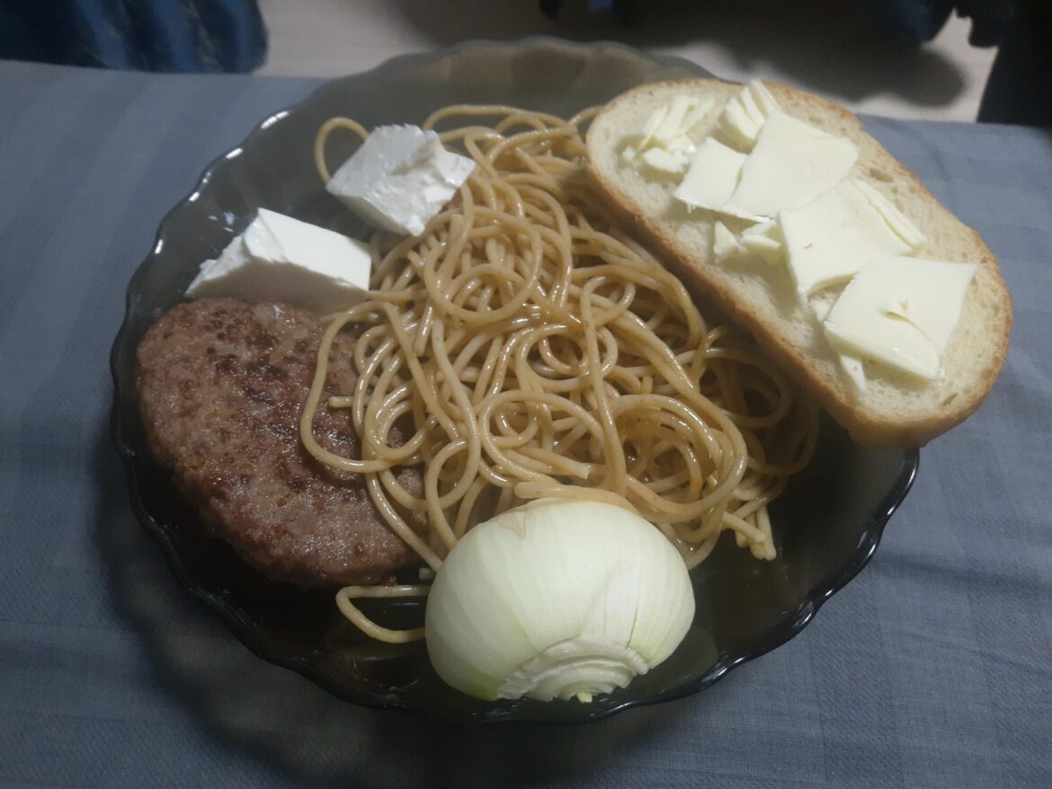 A week old pasta, an old onion and a store-bought patty