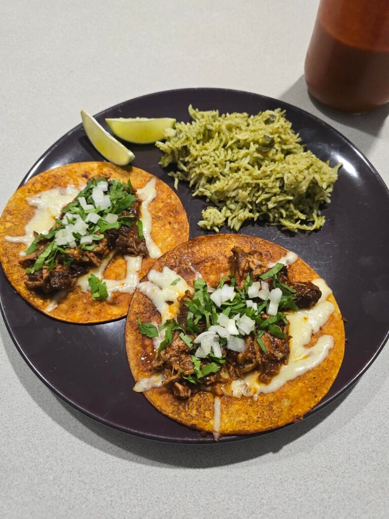 Lamb birria tacos with arroz verde and comino queso with homemade tortilla chips