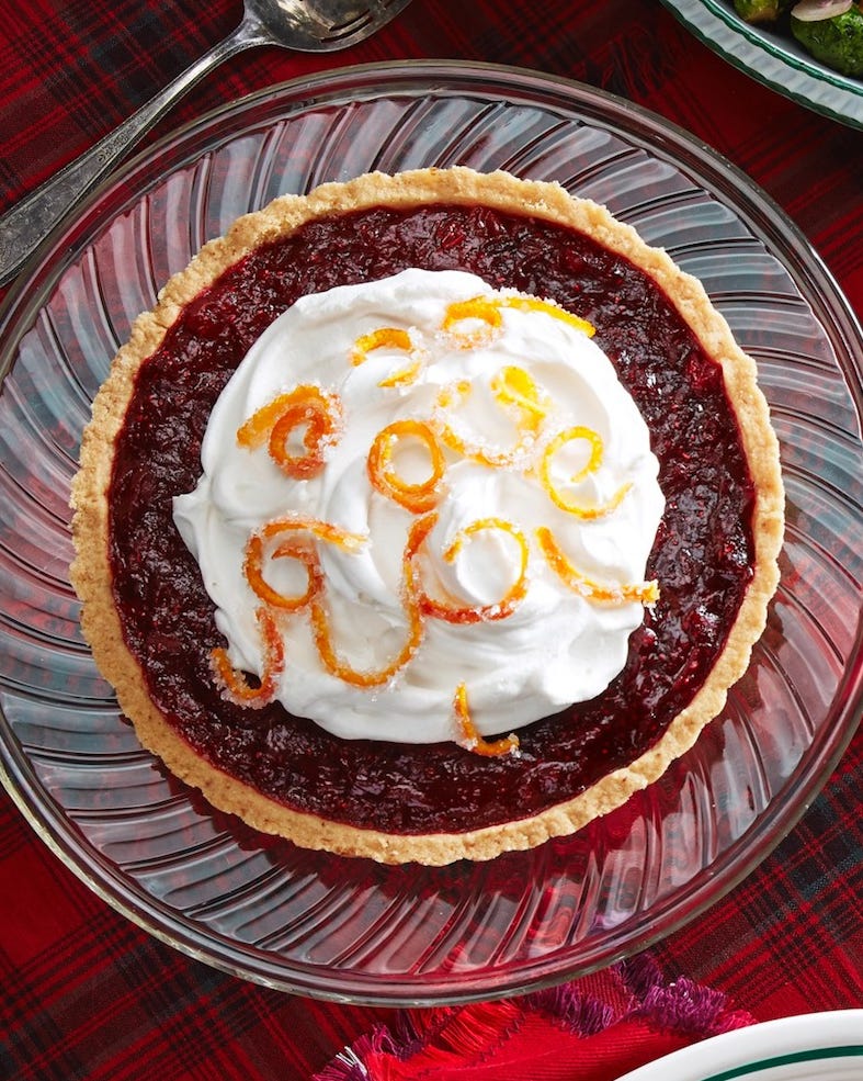 cranberry tart with whipped cream and candied orange peel on top