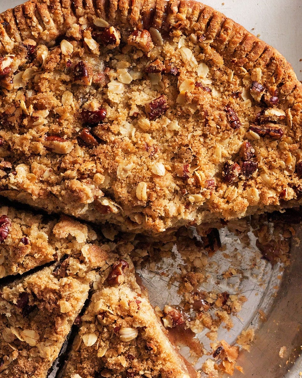 pear crumb pie in a metal pie plate with a few slices cut and a couple of slices removed