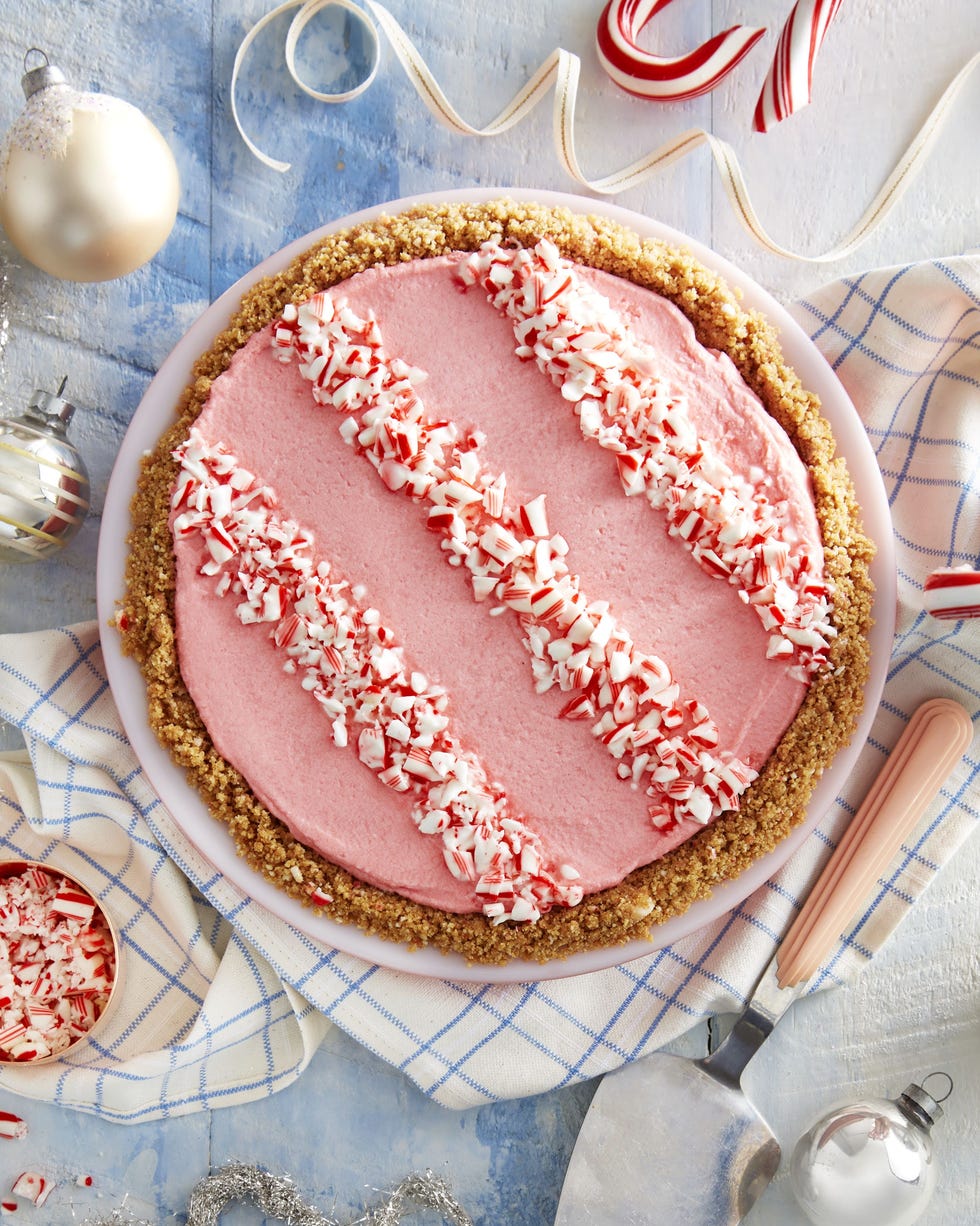 white chocolate peppermint pie in a white pie dish with crush peppermint arranged into a striped design on top
