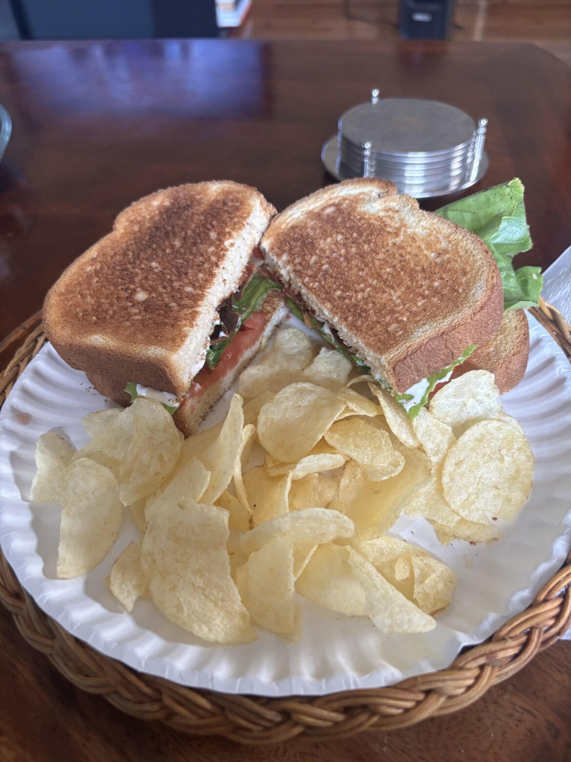 BLT & Lays chips served on a paper plate.