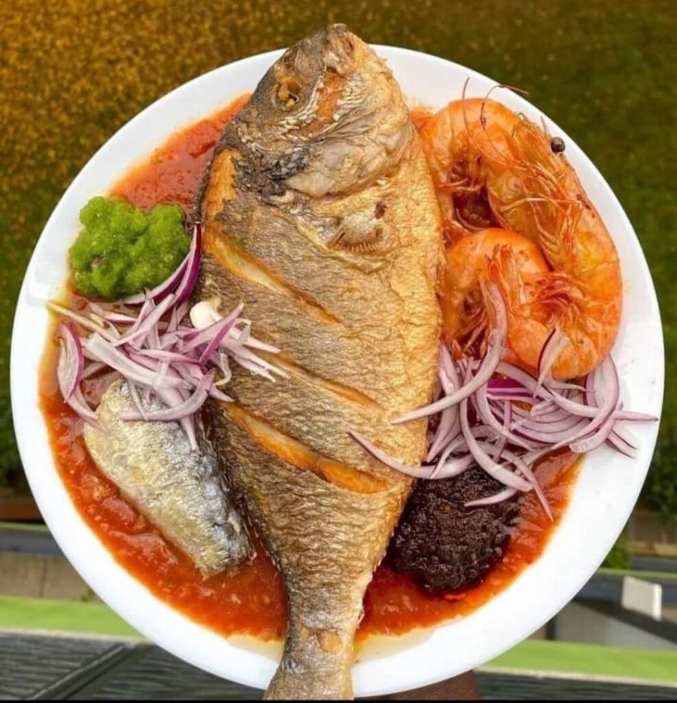 African seafood plate (tilapia, prawns, sardine, red & green peppers, blended tomatoes with sliced red onions - Takoradi, Ghana