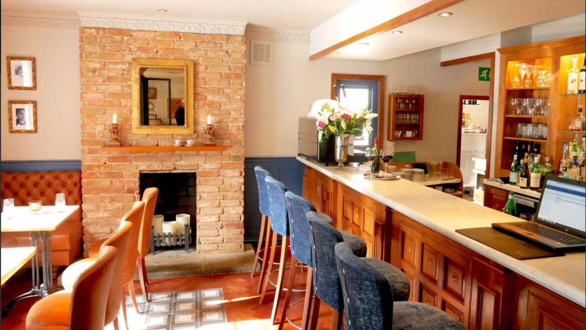 The best restaurant in Britain has been announced – and it’s just an hour from London an image of the bar area in Caldesi in Campagna restaurant which has a brick fireplace and three small tables on the left, and the central bar with high stools on the right