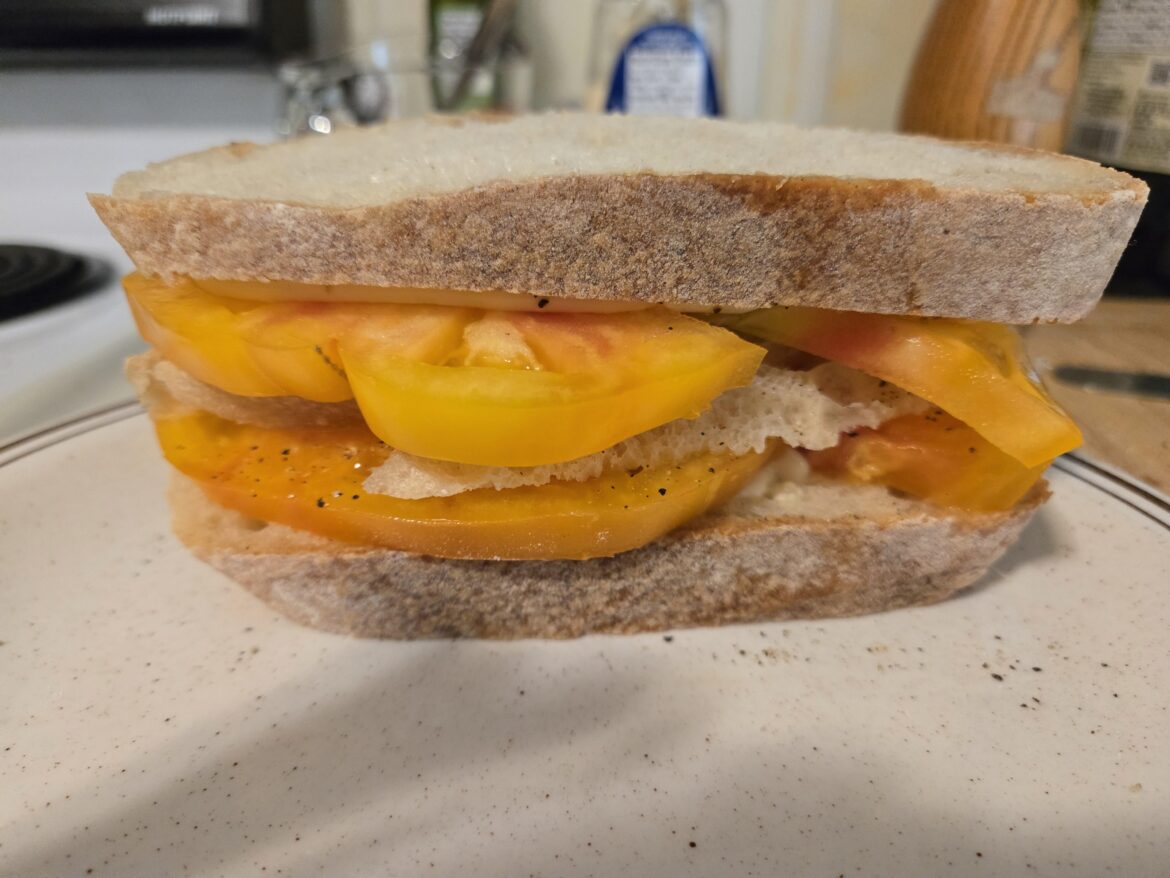Put a thin slice of bread between tomato slices to keep it from sliding