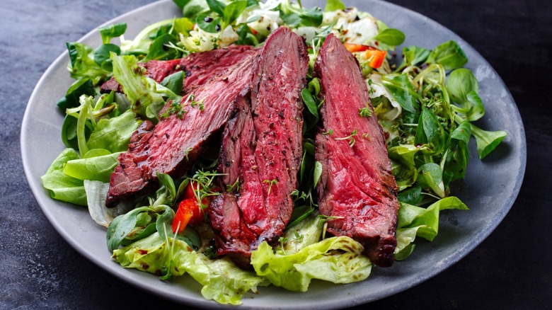 A steak and lettuce salad on a plate