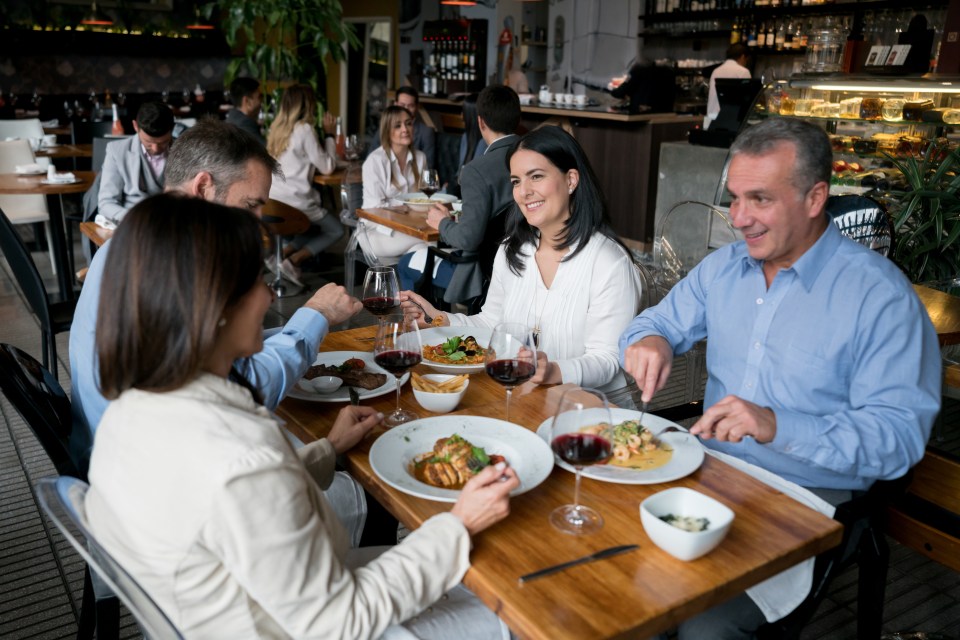 Group of mature adults enjoying a meal together at a restaurant.
