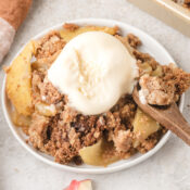 healthy apple crisp with oats and graham crackers topped with a scoop of homemade vanilla ice cream