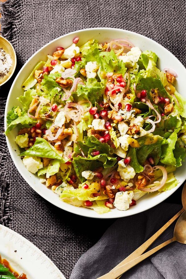 escarole salad with red wine vinaigrette and pomegranate seeds on a white plate