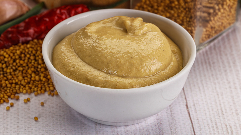 Small white bowl of Dijon mustard