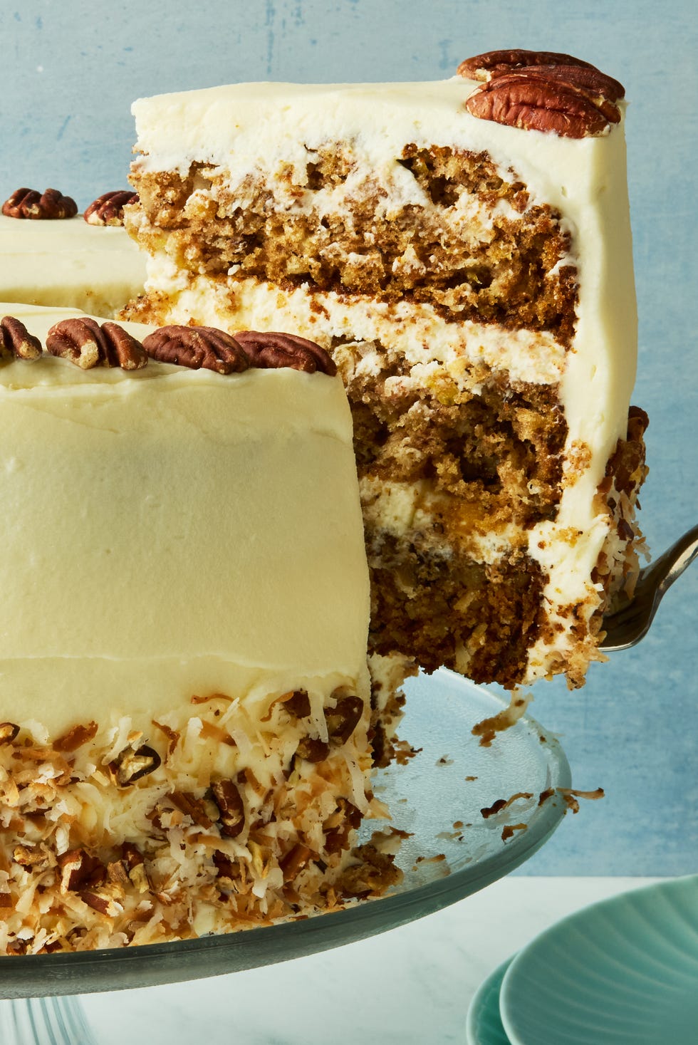 layered cake with frosting topped with pecans