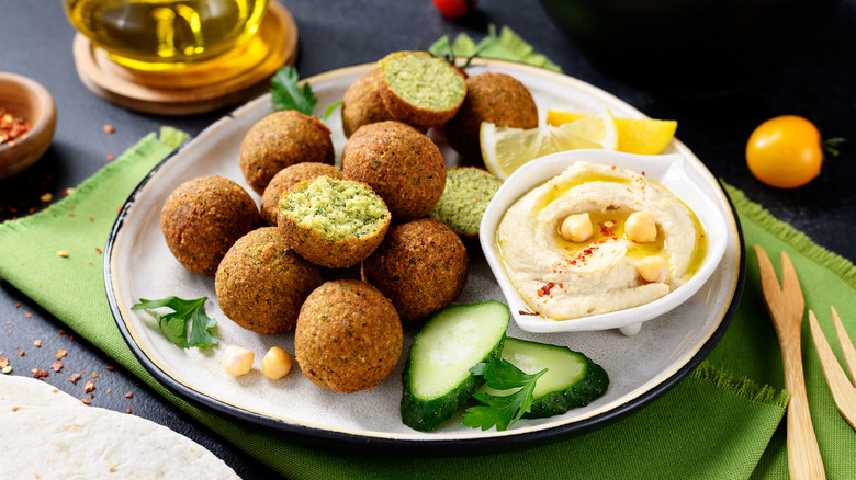 Falafel balls with hummus on a white plate