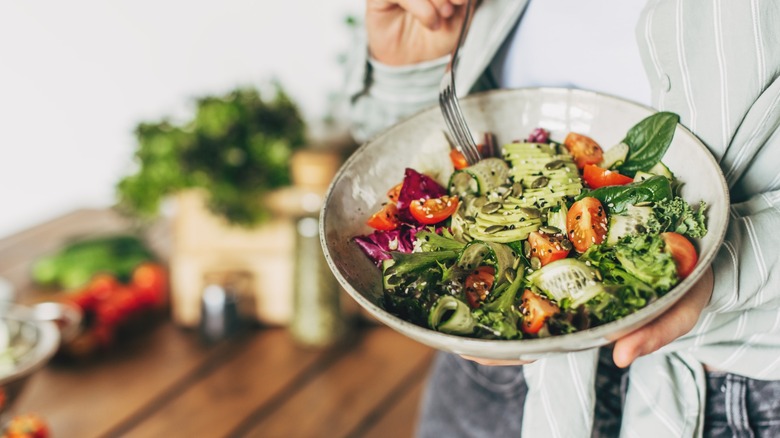 A woman eating a mixed salad