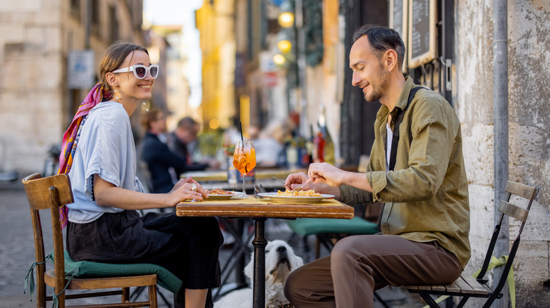 Man and woman dining outside in Italy