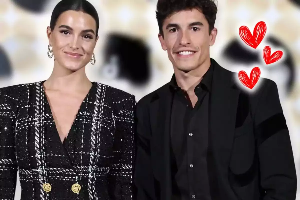 A well-dressed couple smiles at the camera with red hearts drawn next to them against a blurred background.