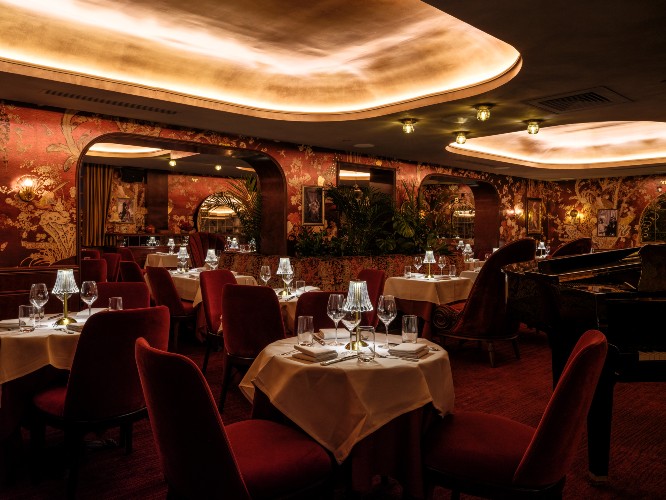 interior of restaurant with red velvet seats and dim lighting