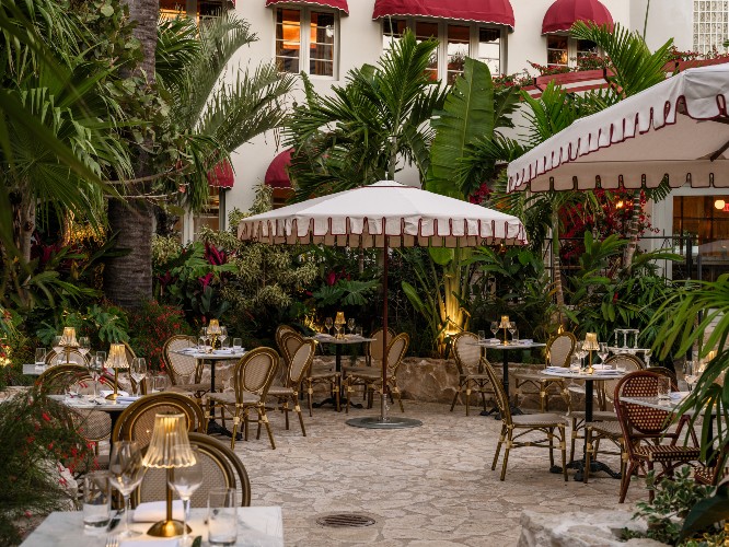 exterior patio with bistro tables and palm trees