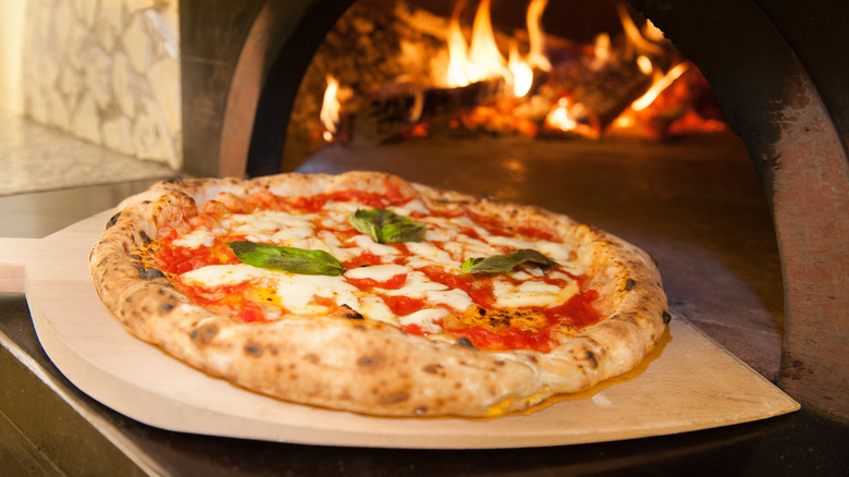Margherita pizza coming out of oven