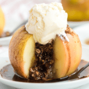 a close up of a brown sugar stuffed baked apple with a scoop of ice cream on top in a white dish