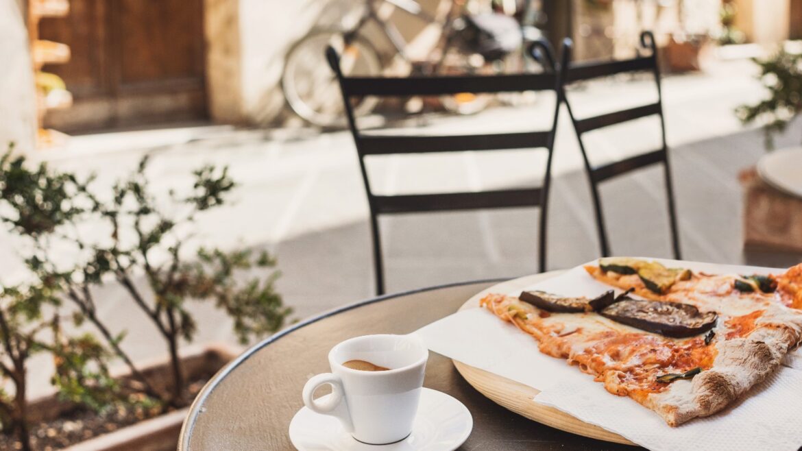 9 Traditional Italian dishes you should try when in Italy Traditional Italian dishes of pizza and coffee on top of an outdoor table in Italy