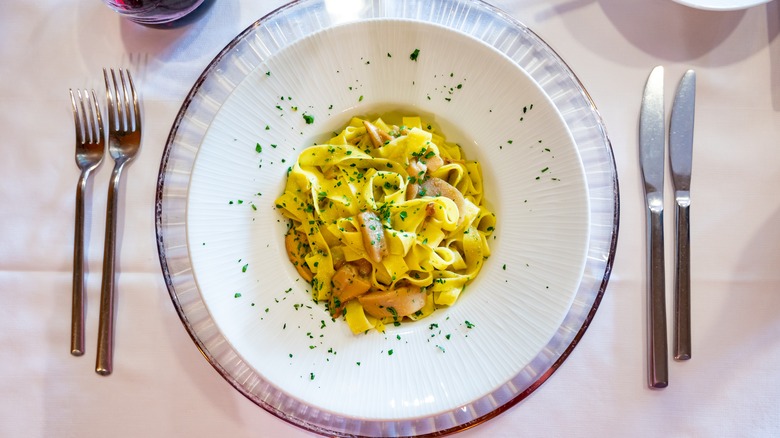 tagliatelle in bowl with utensils