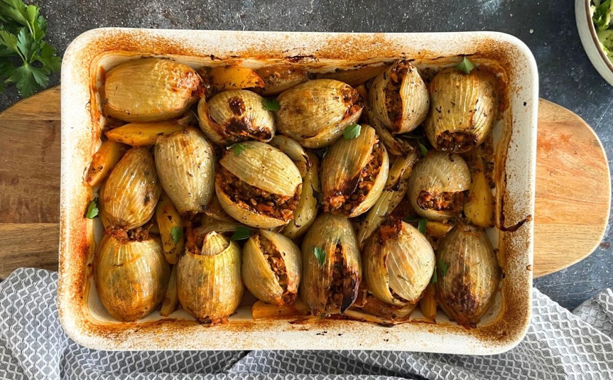 A pot filled with stuffed onions with a lentil and bulgur filling