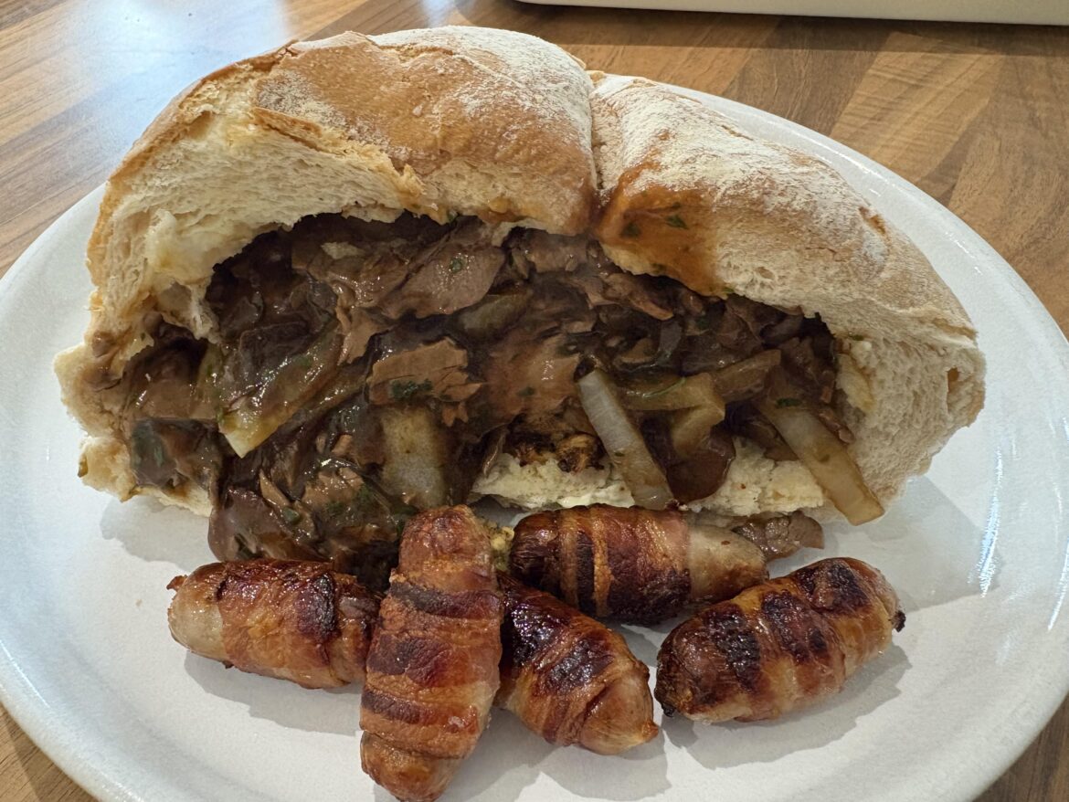 Beef, onions, gravy, and stuffing inside a hollowed out cob yesterday. Few pigs in blankets on the side too.