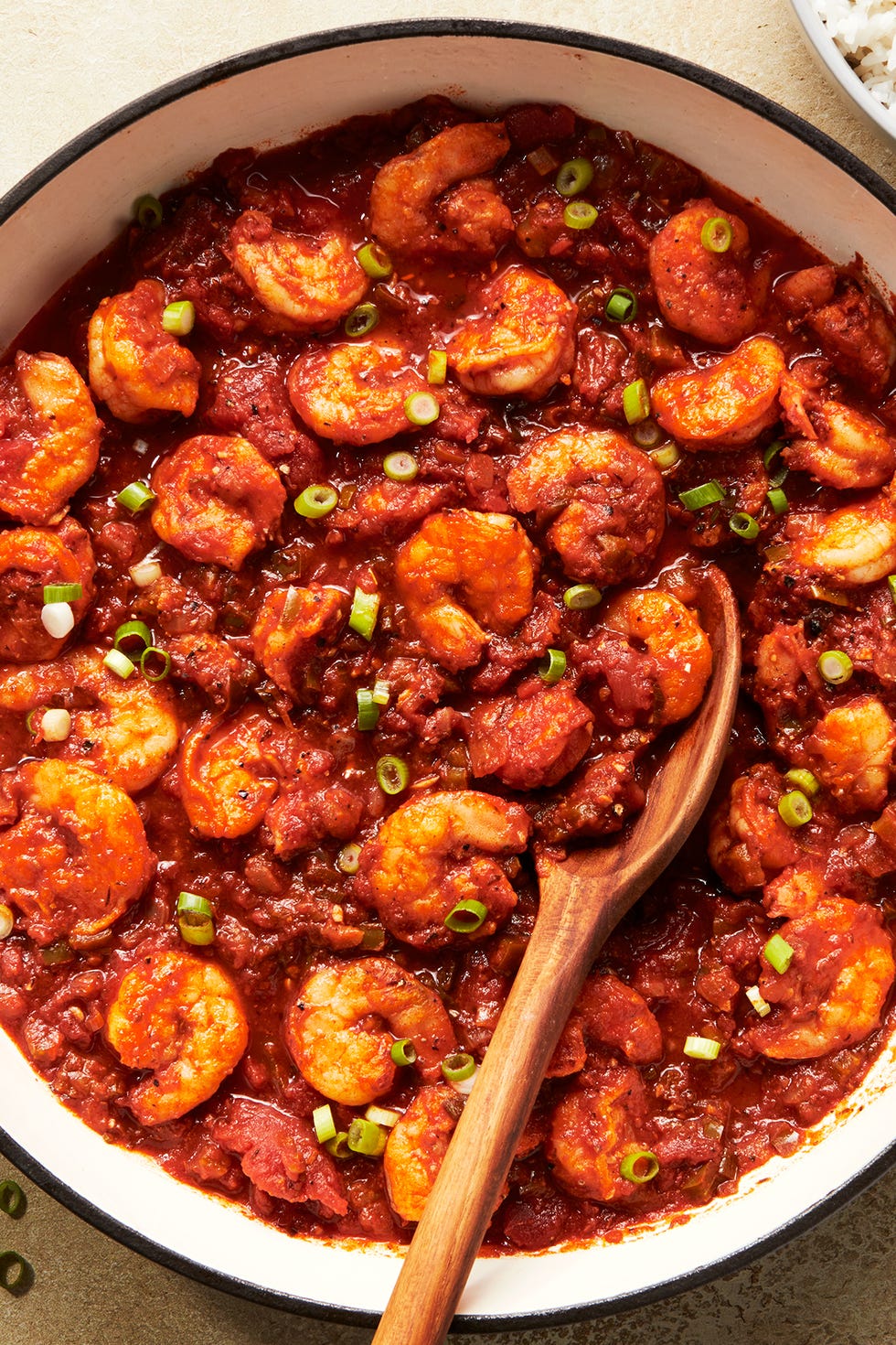 shrimp in a tomato based stew topped with chives and served with rice