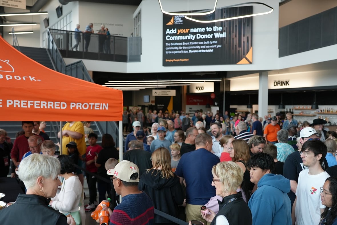 A crowd inside an arena lobby.