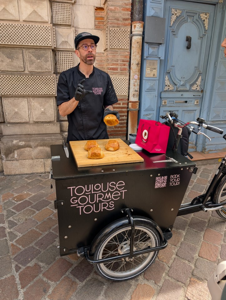 A Toulouse Gourmet Tours guide showing pastries on a cart.