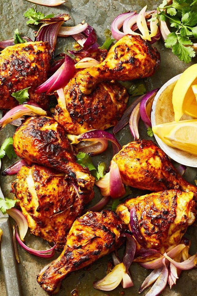 charred tandoori chicken with red onions and lemon slices
