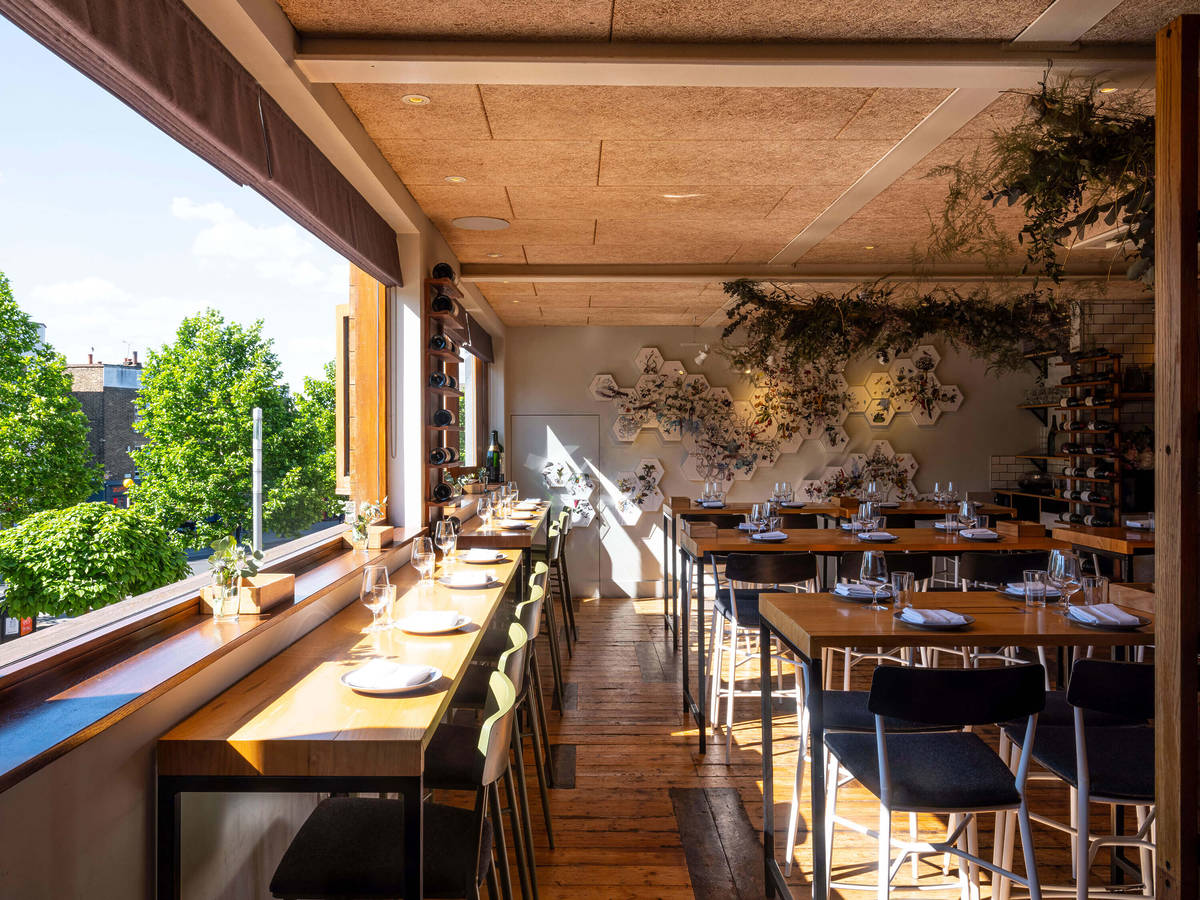 sun streaming into the dining room at upstairs, with a counter facing out a huge wall-spanning window to the side of the dining room