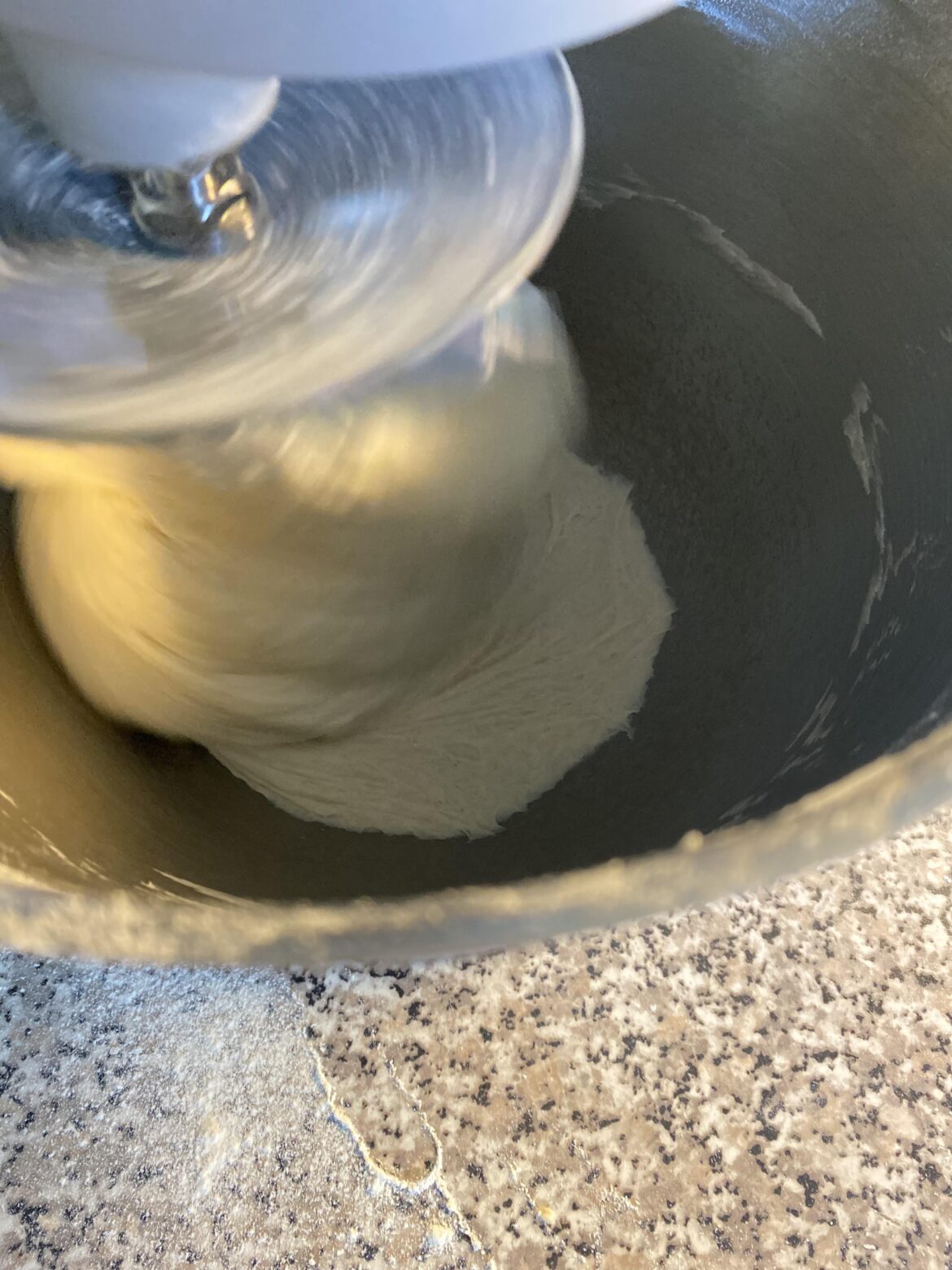 How can I stop my pizza dough accumulating at the bottom of the mixer?