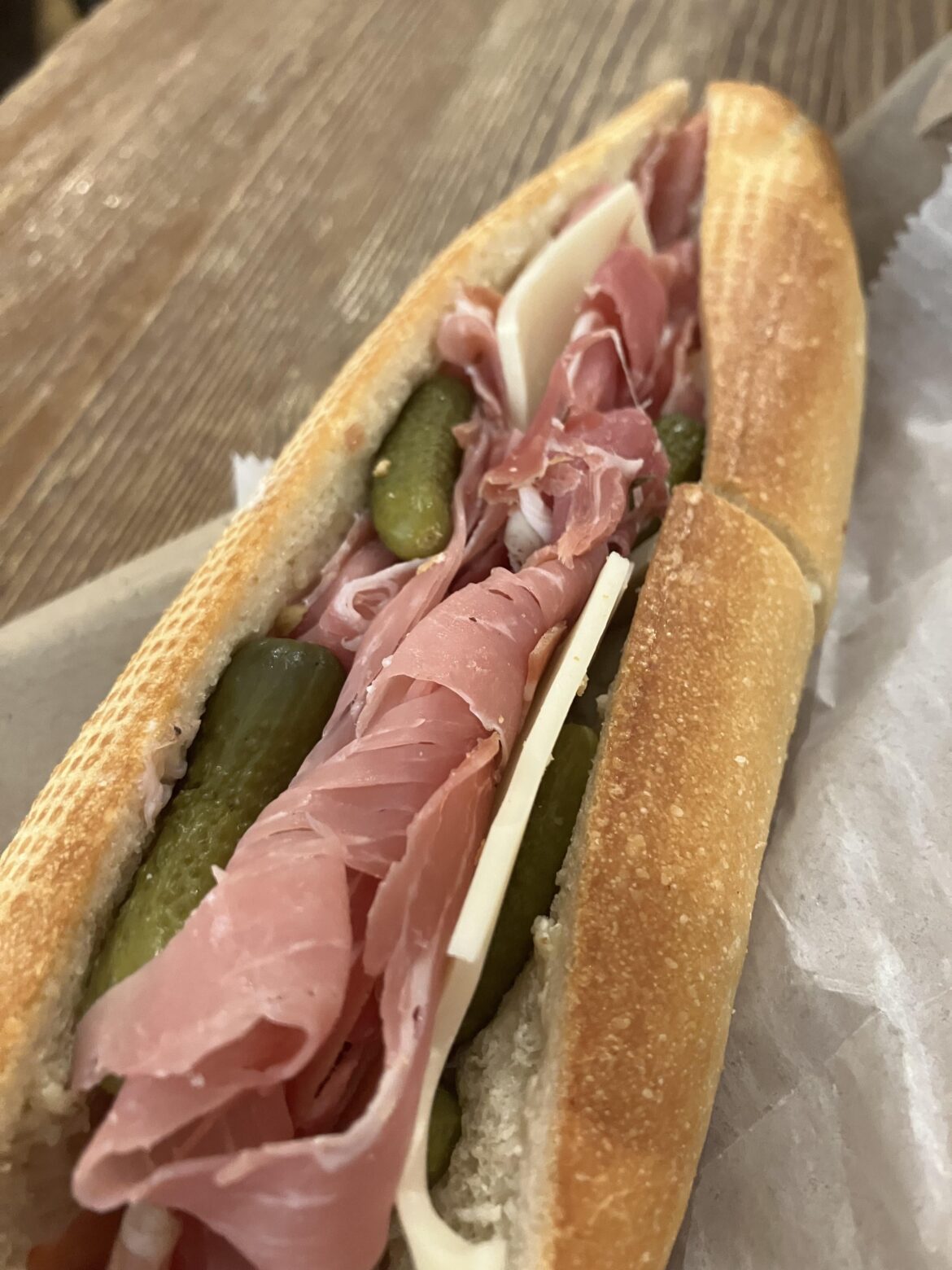Prosciutto, pickles, Swiss and butter on fresh baguette