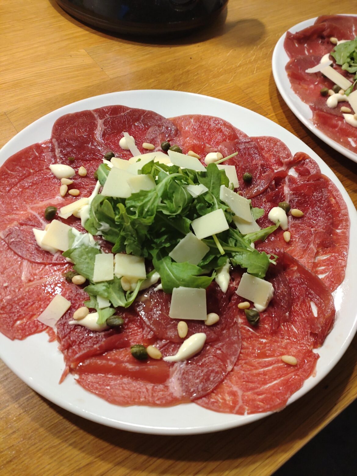Homemede carpaccio, topped with olive oil, arugula, capers, pine nuts, Dijon cream, parmesan.