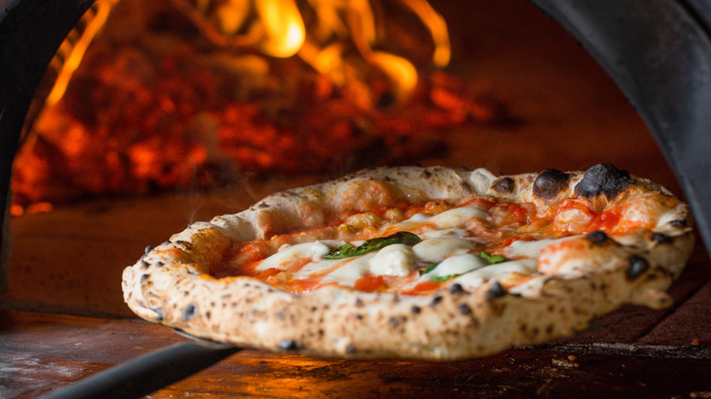 Neapolitan Margherita pizza coming out of a wood-fired oven