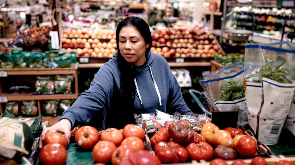 woman picking tomatoes at the market
