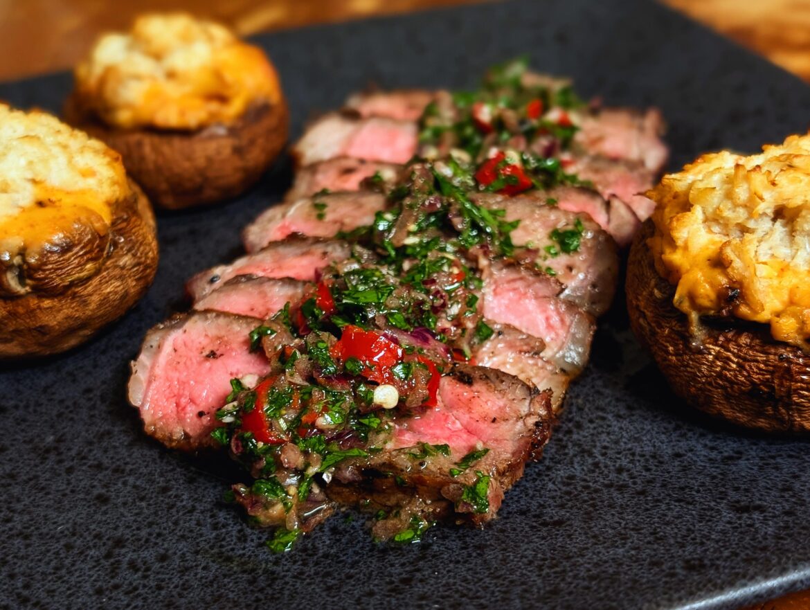 Charcoal grilled NY strip, spicy chimichurri, and stuffed cremini mushrooms