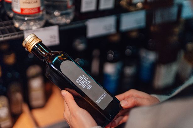 Young woman reading the nutrition label on bottle in health food store. Mockup image for food packaging.
