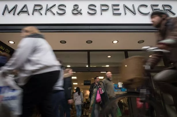 Christmas shoppers pass a branch of Marks and Spencer 