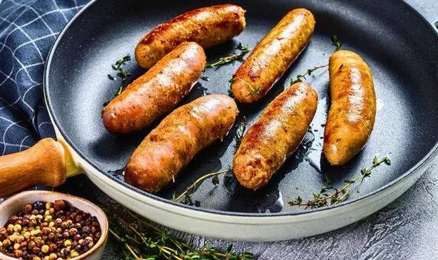 Picture of seasoned sausages cooking in a pan