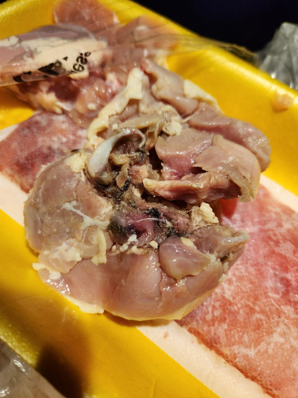 Boneless thighs from Walmart. White part is bone/cartilage. What's the black stuff?