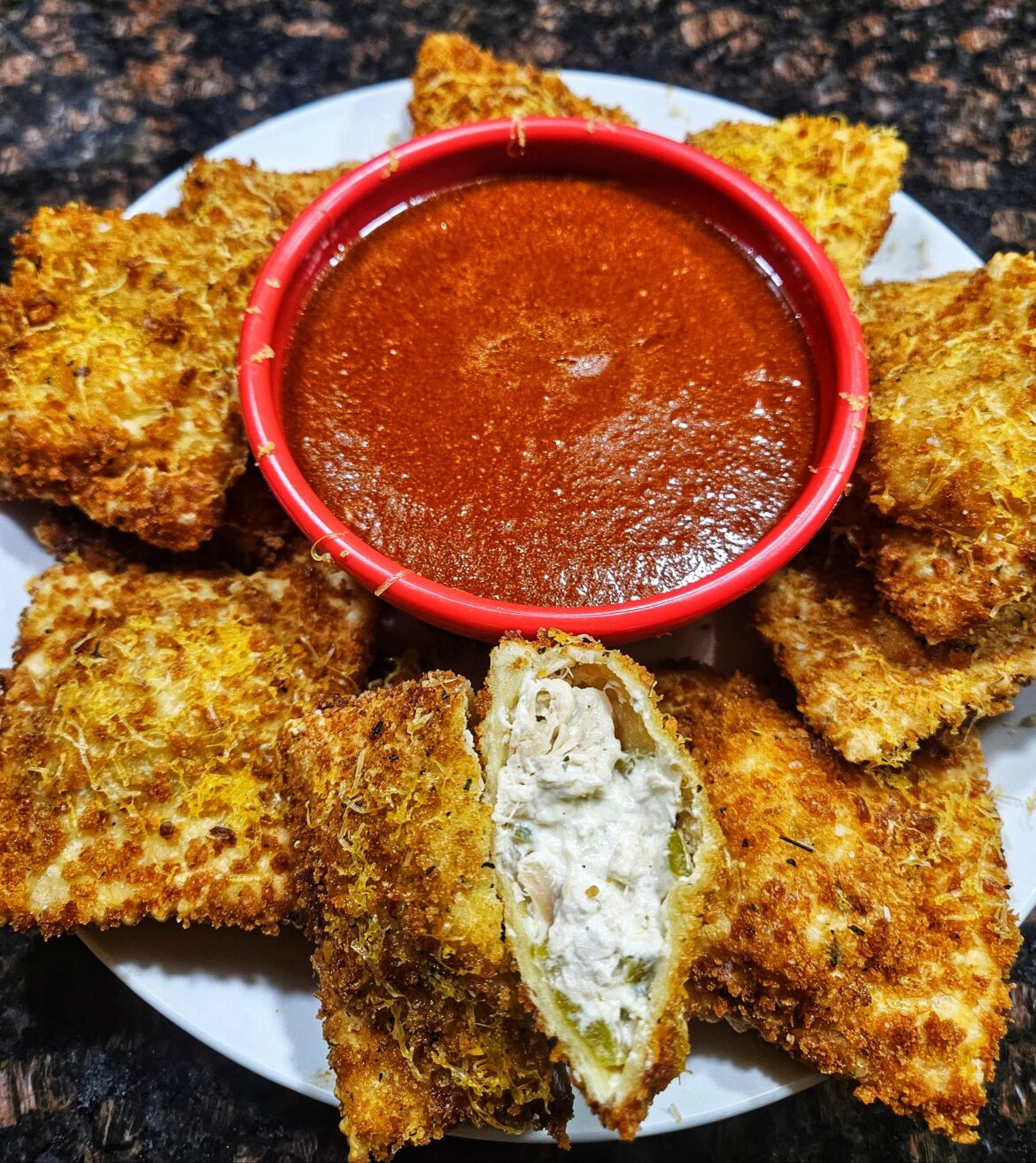 Fried ravioli with Hatch green chile and chicken. Red chile for dipping.