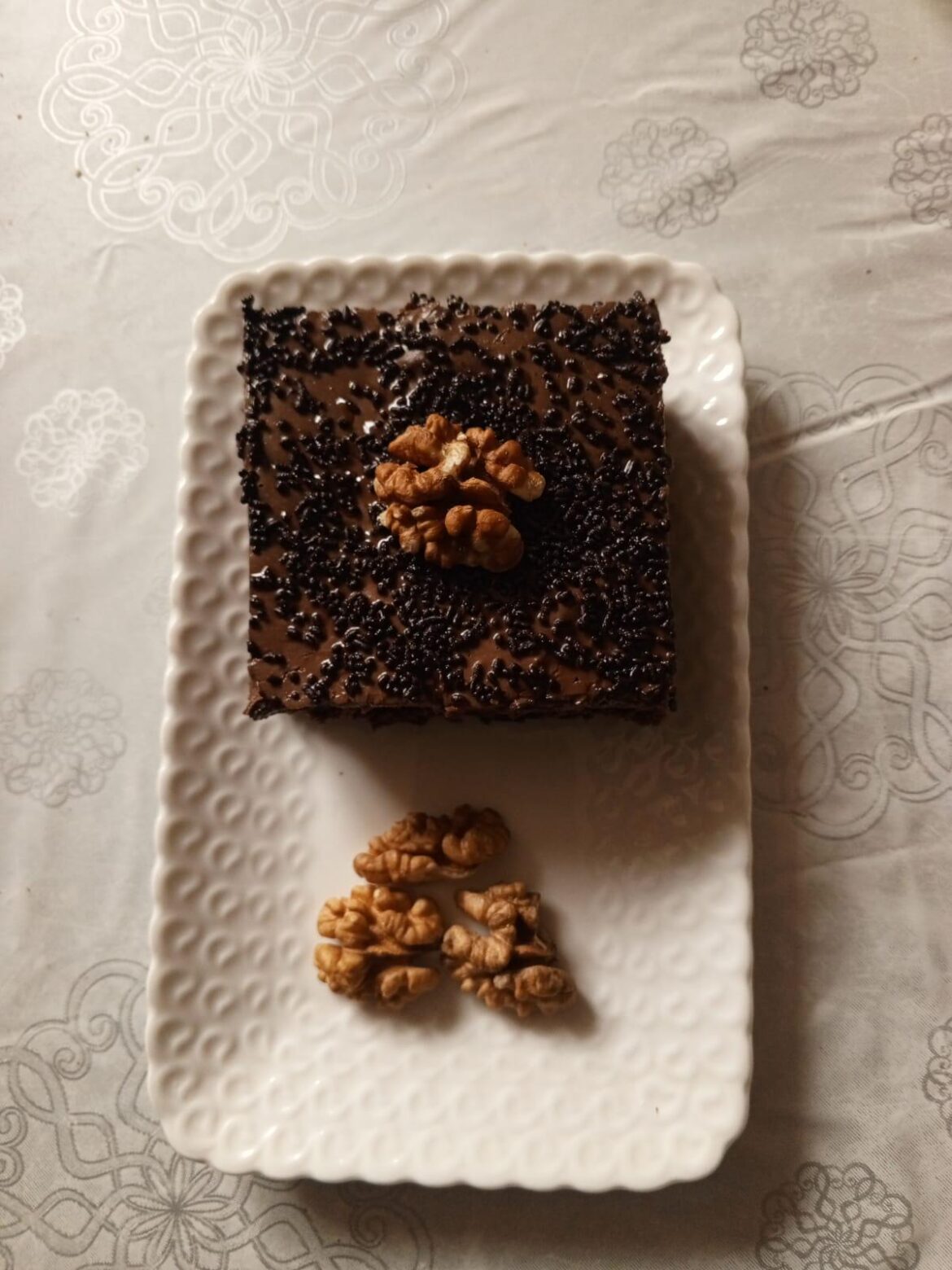 Homemade chocolate fudge cake with walnut garnish