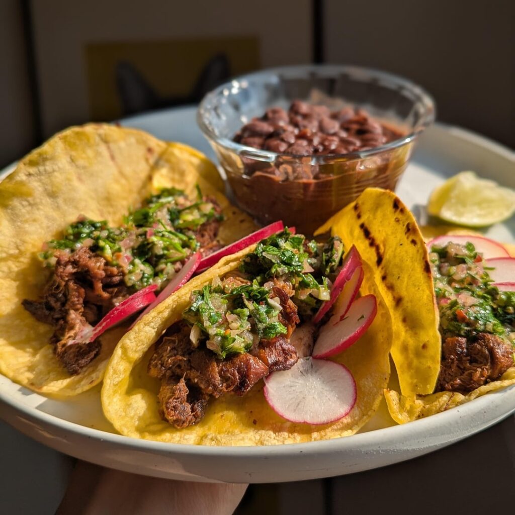 carne asada tacos with cilantro chimichurri and spicy sazón black beans.