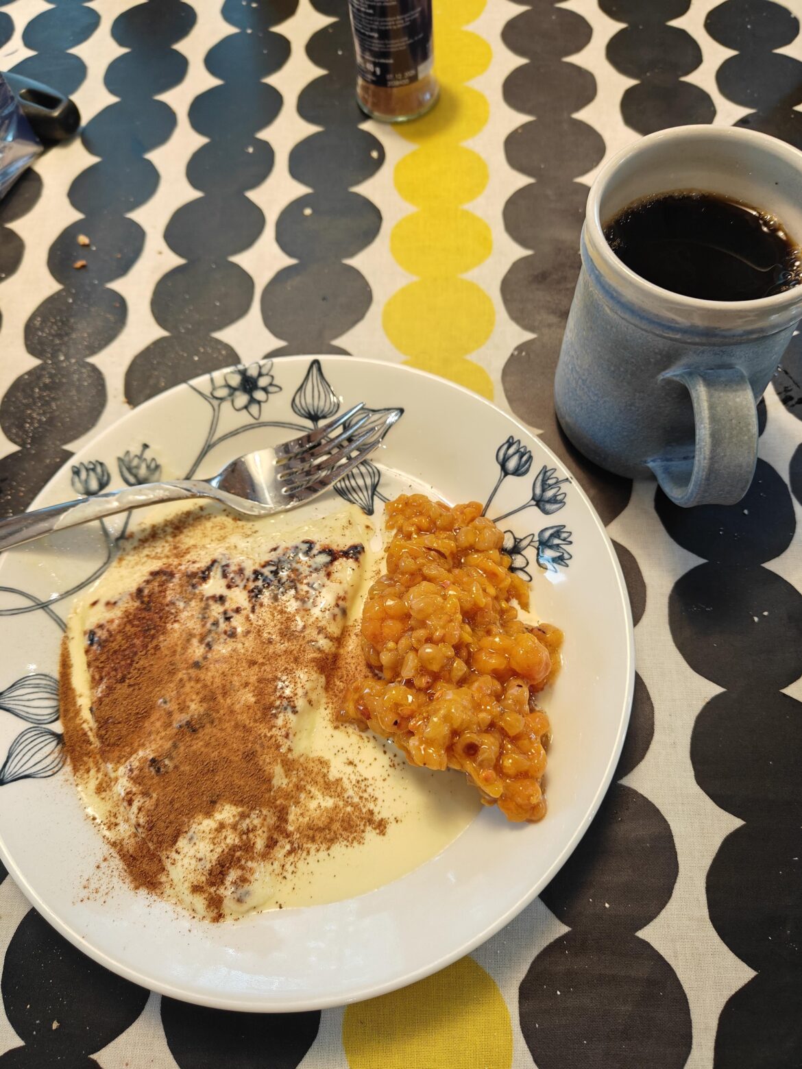 Baked cheese dessert with vanilla sauce, cinnamon, and cloudberries