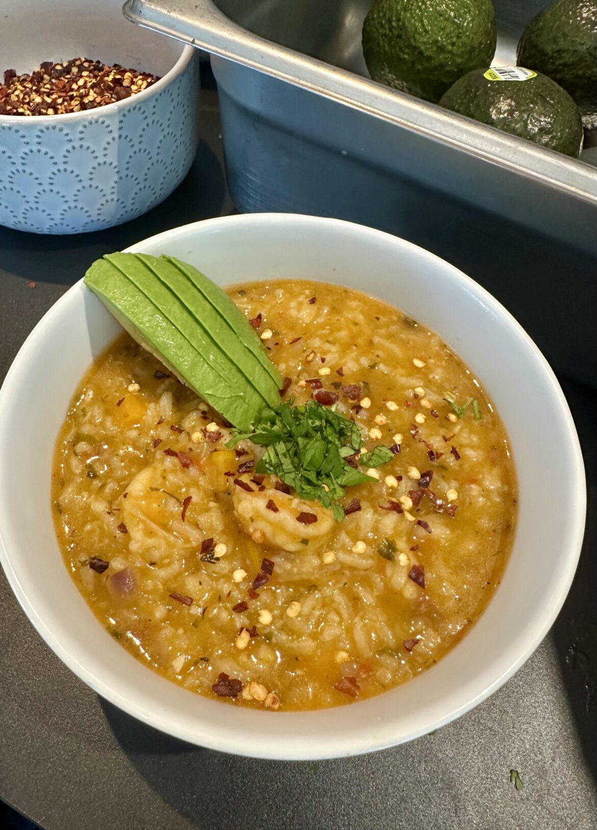 Soupy rice with shrimp and avocado.