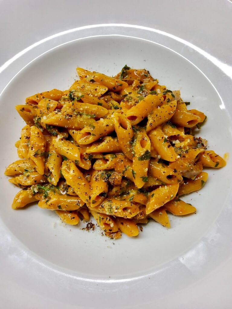 Mezze penne rigate in a garlic, guanciale, white wine, parsley, paprika, pecorino and black pepper sauce