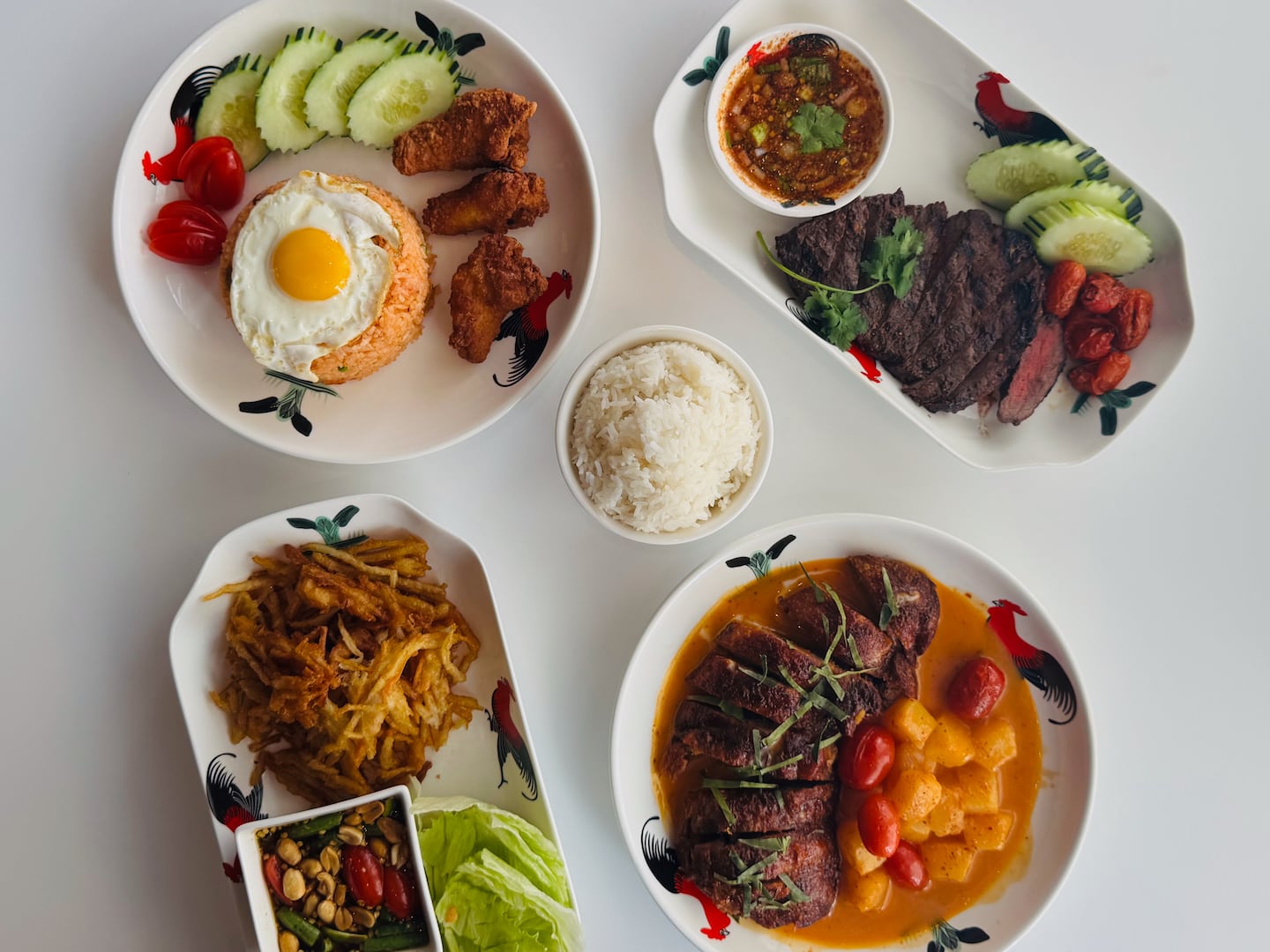 Crispy papaya salad, red curry with duck (kang phed ped yang), American fried rice (with fried chicken), and jeaw steak at Phed Phed in Providence, R.I.