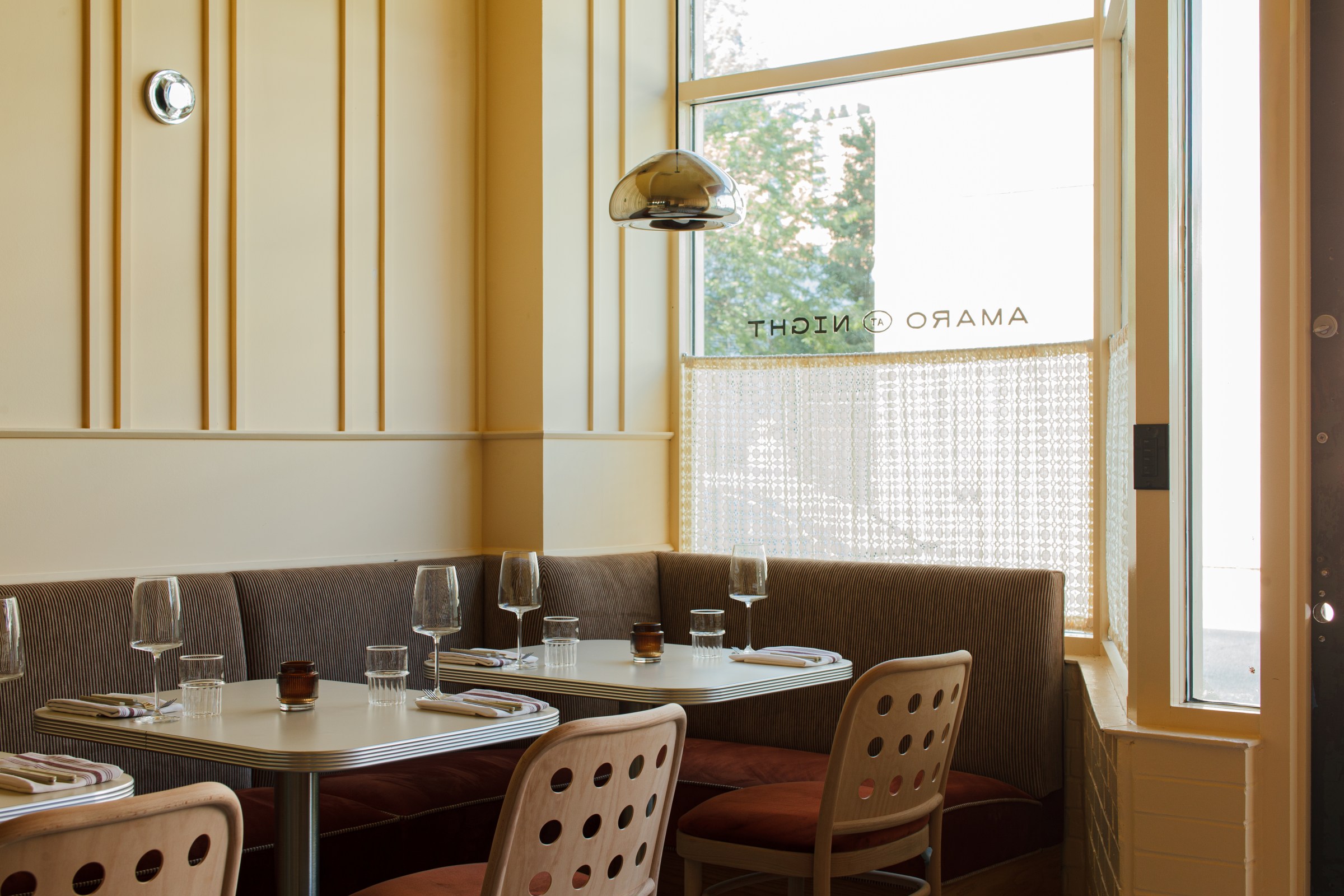 A dining area with booth seating next to windows.